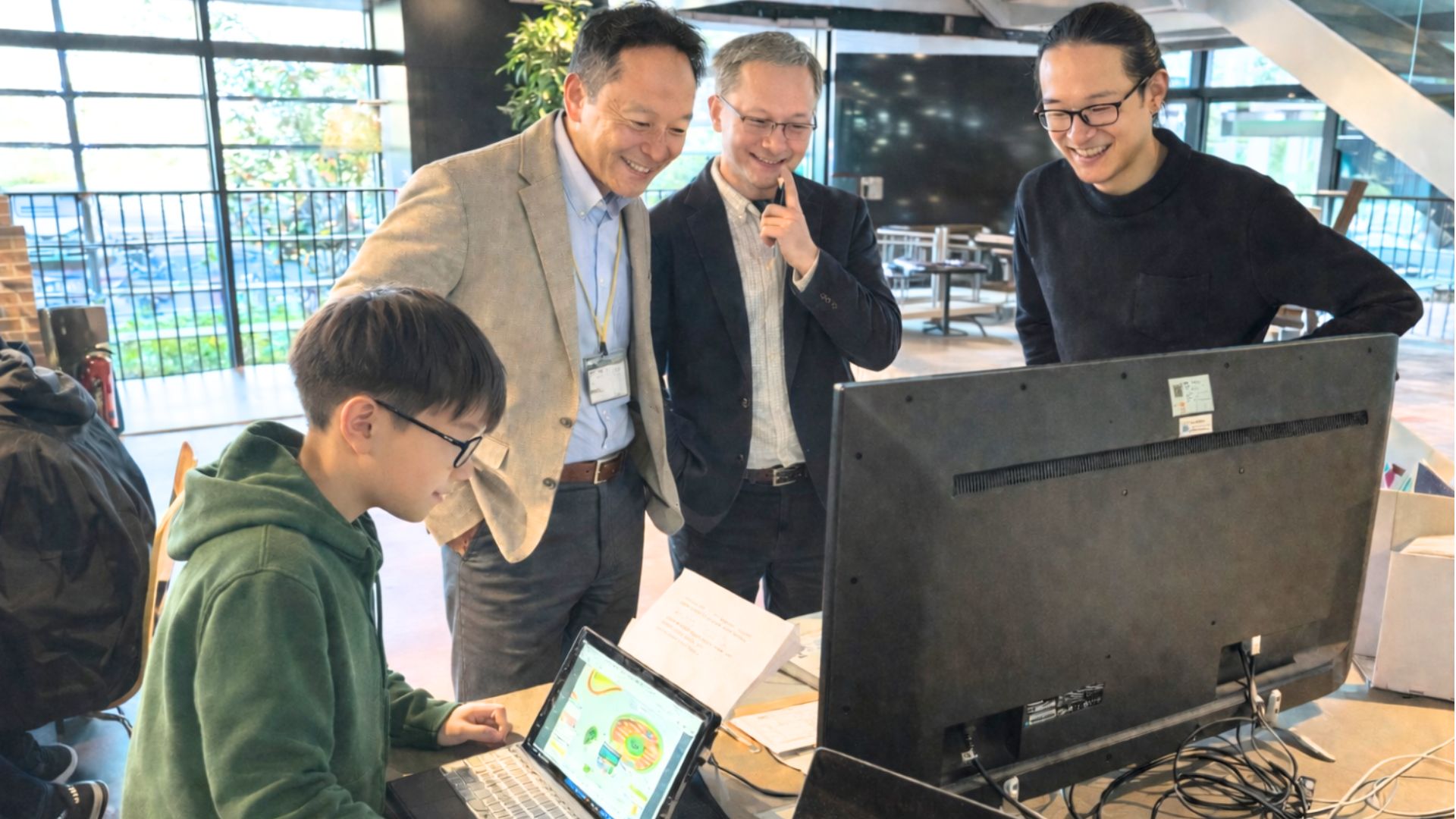 子どもが地域で活動する大人たちに自分の制作物を見せている様子