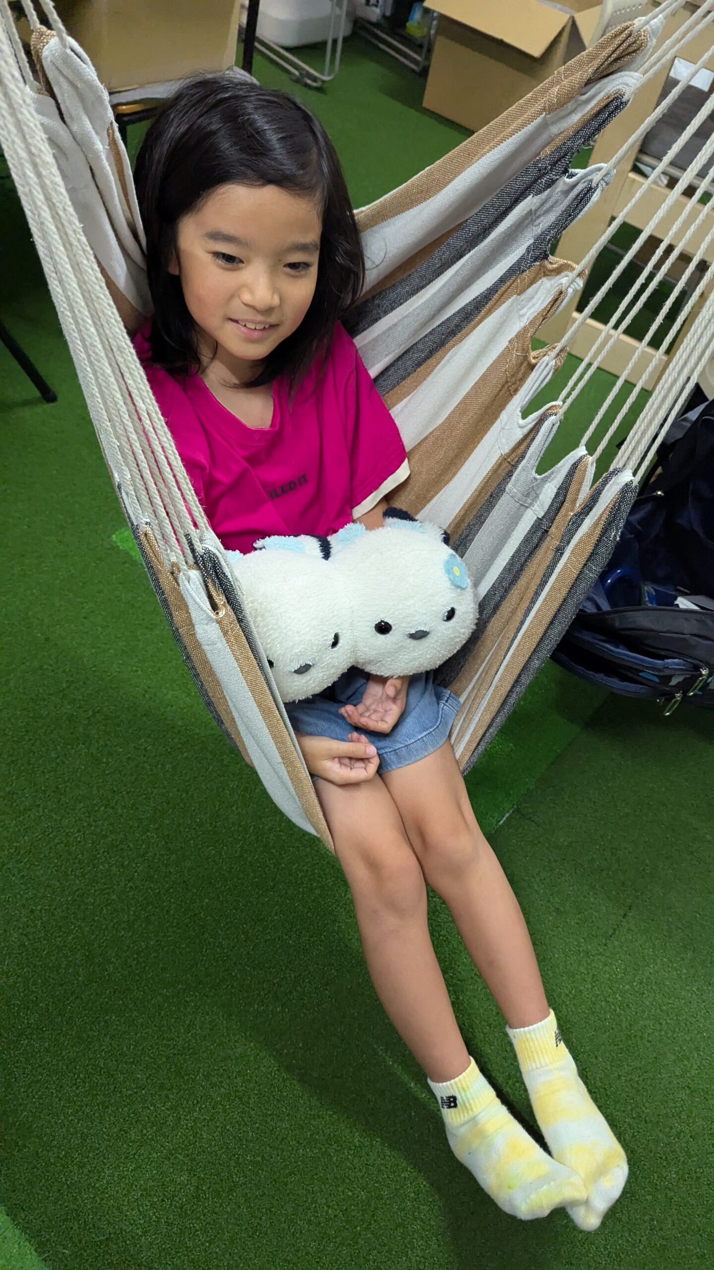 休憩時間、ハンモックでぬいぐるみと過ごす子ども