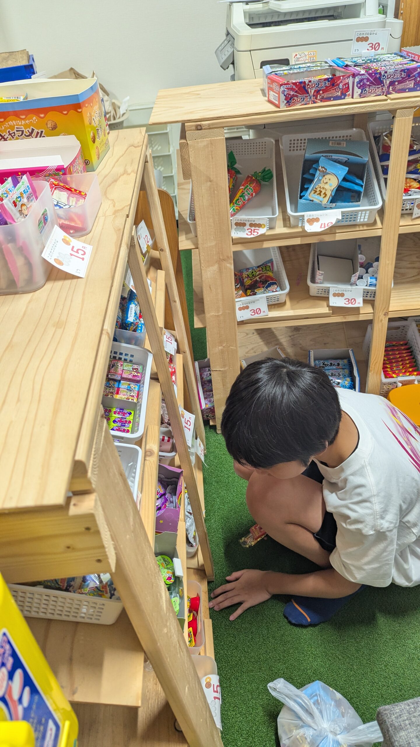 実際の駄菓子屋「しんじょのねどこ」の商品棚を見学する子どもたち
